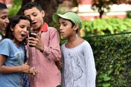 Niños en la Escuela San Columba en Delhi, India, se toman fotos con su smartphone.