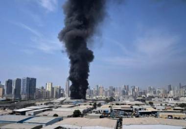 Una columna de humo negro se eleva desde un almacén en la zona industrial de Sharjah, Emiratos Árabes Unidos, tras los informes de ataques iraníes en Dubái, Emiratos Árabes Unidos, el domingo 1 de marzo de 2026.