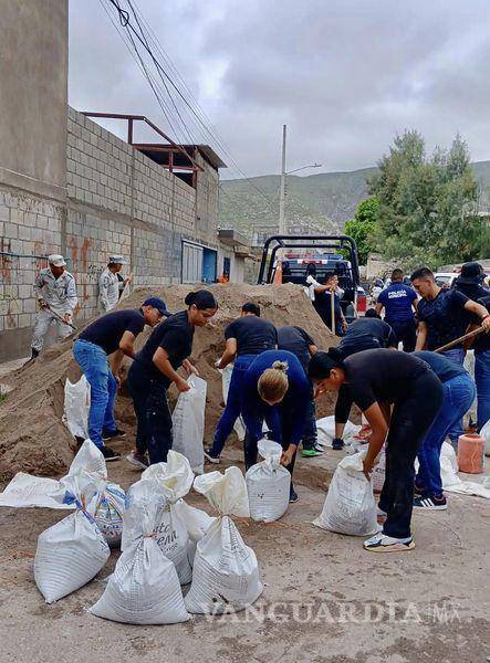 $!Cadetes y elementos de la Policía Municipal trabajan en el llenodo de costales.