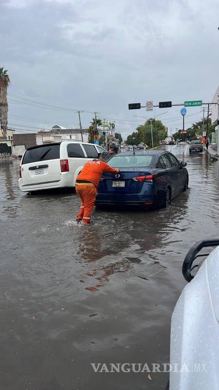 $!Personal del Municipio ayuda a conductores varados en medio del agua.