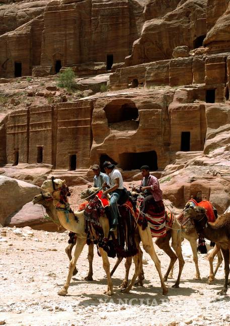 $!Grupo de beduinos en camello delante de algunas tumbas en el enclave arqueológico de Petra, en Jordania. EFE/Ballesteros/cg.