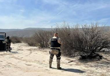 Agentes de la AIC y personal militar trabajan en el lugar donde fue encontrado el cuerpo calcinado, en un predio baldío de Torreón.