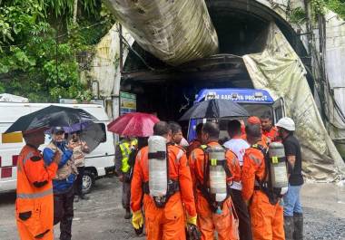 Miembros del equipo de rescate con bombonas de oxígeno ante un túnel de construcción en un proyecto hidroeléctrico en el pueblo de Samardung, unos 40 kilómetros (25 millas) de Gangtok, India, el martes 21 de julio de 2026, informó la AP.