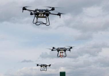 Un dron explosivo espera mientras los civiles salen de la zona con un pequeño perro blanco y negro abriendo camino.