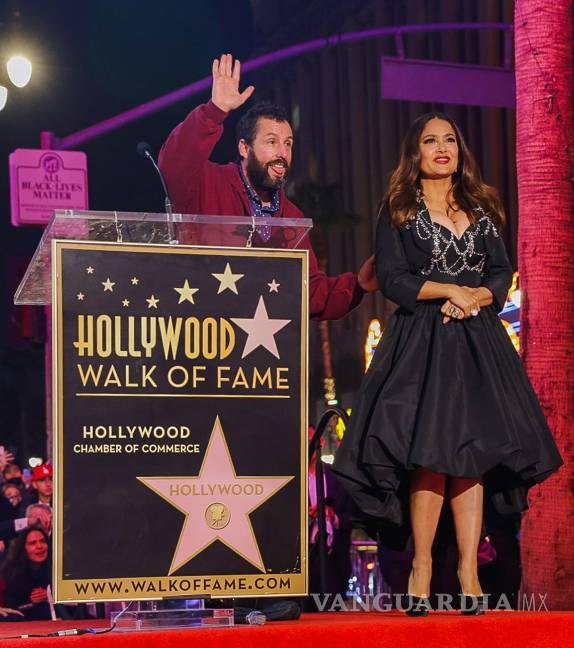 $!El actor Adam Sandler pronuncia unas palabras en nombre de la actriz Salma Hayek antes de recibir la estrella en el Paseo de la Fama en Hollywood (EU). EFE/Phillip Kim