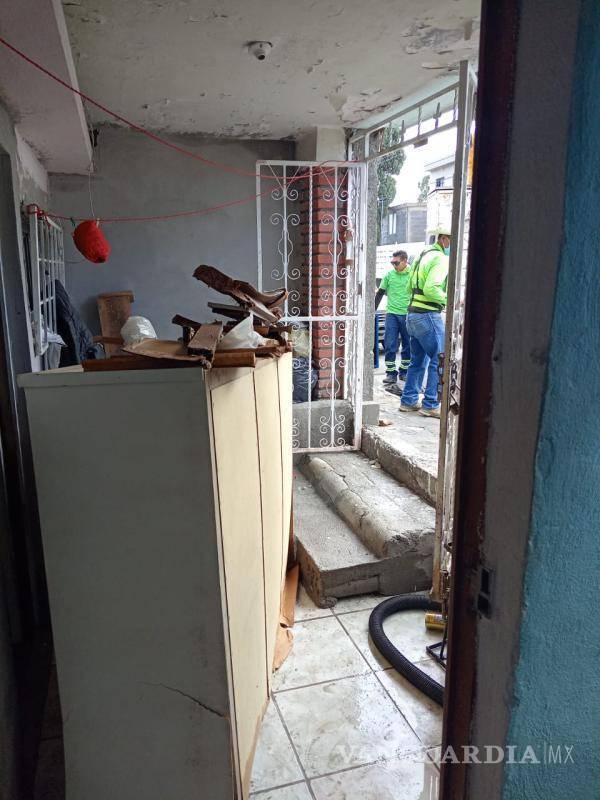 $!Trabajadores de Protección Civil ayudaron a la familia a sacar el agua y muebles que se dañaron.