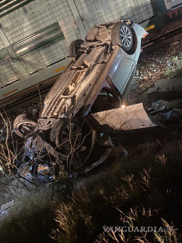 $!El automóvil quedó junto a las vías del tren, en un canal.