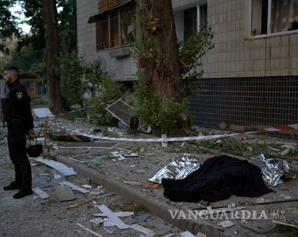 $!Un policía, junto a los cadáveres de dos personas muertas durante un ataque nocturno ruso en Kiev, Ucrania, el 20 de agosto de 2026.