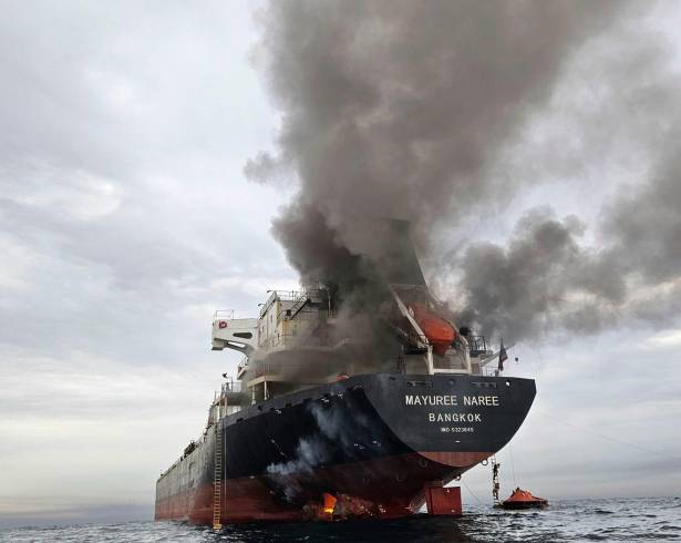 Humo emerge del Mayuree Naree, un buque granelero con bandera de Tailandia, tras ser impactado por un proyectil en el estrecho de Ormuz, al norte de Omán, el 11 de marzo de 2026.