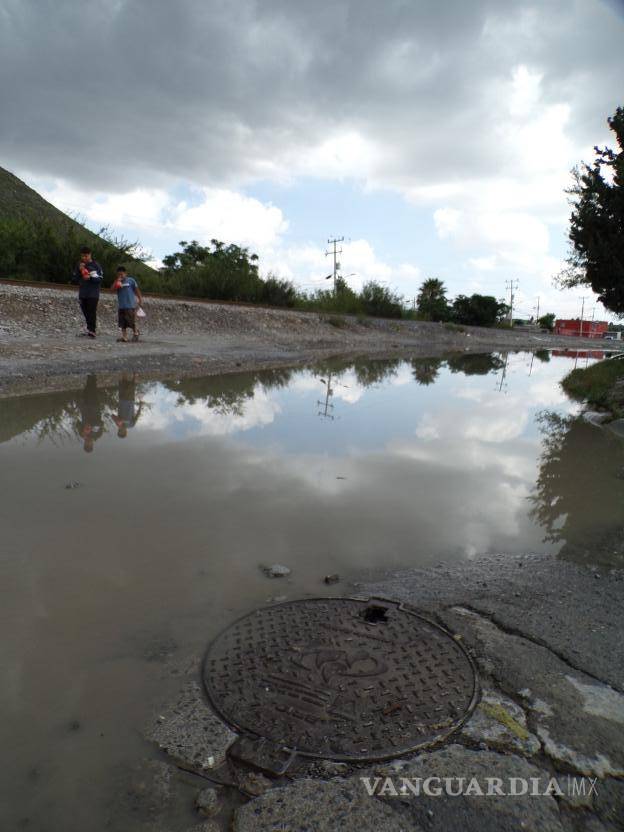 $!El agua brota por las coladeras y forma charcos pestilentes en plena calle.
