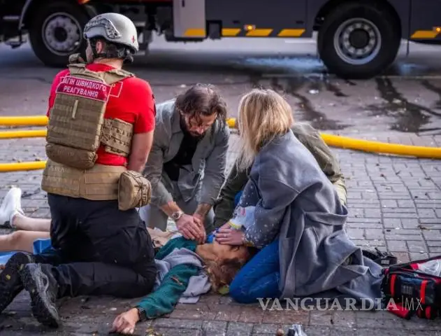 $!Varias personas reaniman a una mujer herida en un ataque con drones rusos contra el edificio de la Academia Nacional de Ciencias el 28 de septiembre de 2026.