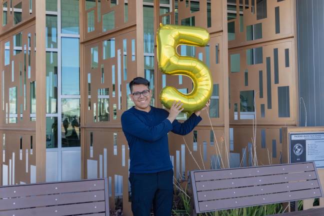 Joseph Parra Miguel, de 18 años e hijo de inmigrantes mexicanos, sosteniendo un globo en forma del número cinco en alusión a su logro de 5 millones de dólares en becas.