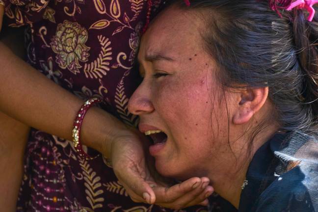 Una niña llora mientras espera noticias de sus familiares muertos tras las inundaciones repentinas en Bidur, en el distrito de Nuwakot, Nepal, el 27 de agosto de 2026.
