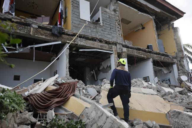Un socorrista observa una edificación afectada por el terremoto de magnitud 7,7 que sacudió el sureste de Panamá, con una profundidad de 10 kilómetros y generó daños en varios edificios y carreteras cercanas a la localidad de Tonosí, epicentro del temblor, este viernes en Penonomé.