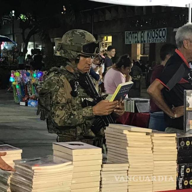 $!“Un lector en cada hijo te dio”, marino deja su arma y sostiene un libro, en Feria de Acapulco