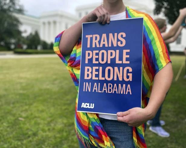 Una persona sostiene un cartel que dice “Las personas trans pertenecen a Alabama” en una protesta frente al Capitolio estatal de Alabama en Montgomery.