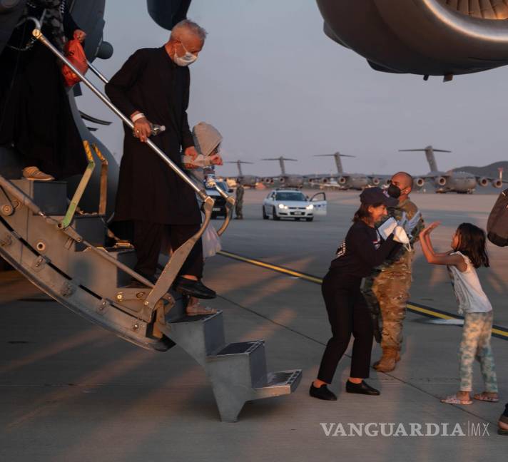 $!un miembro de la Organización de Servicios Unidos (CR), chocando los cinco con un evacuado afgano cuando parten de un avión C-17 Globemaster III en Ramstein Base aérea, Alemani. EFE/EPA/Senior Airman Taylor Slater/US AIR FORCE