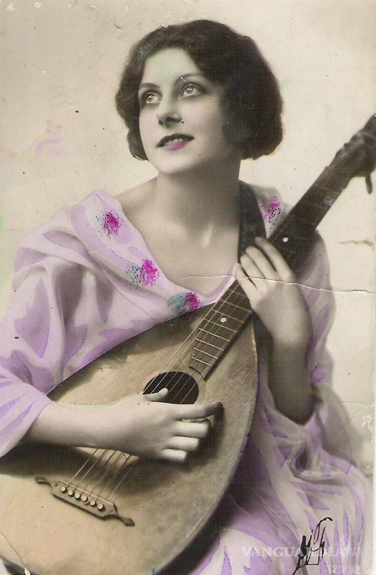 $!Postal de Felipe de Jesús Granada Valero a Marcelina Flor, fechada el 26 de abril de 1927. La llama “Querida Chela”, imagina un futuro a su lado y se despide como “tu fiel amante”; al frente aparece una mujer con un instrumento de cuerda en una imagen coloreada.