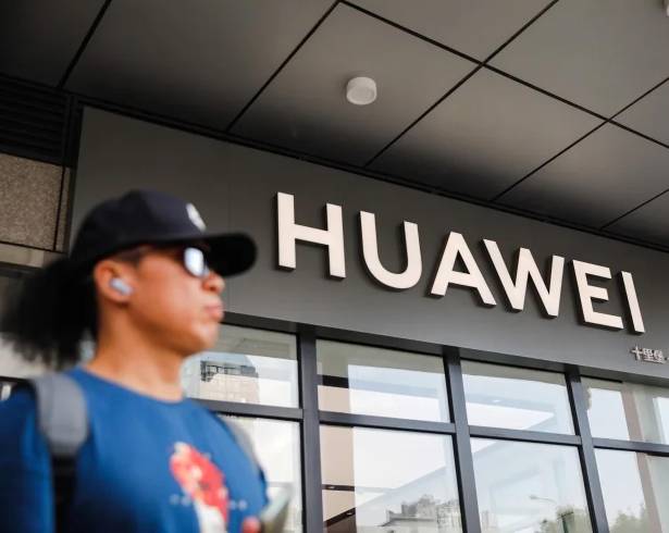Un hombre junto a una tienda de Huawei, en Pekín, China. La compañía china es uno de los primeros blancos de Washington en una disputa comercial que inició durante el primer mandato de Donald Trump.