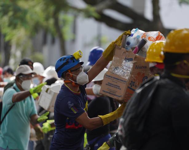 Los rescatistas distribuyen paquetes de alimentos a los equipos de rescate y voluntarios que buscan entre los escombros cuatro días después del terremoto.