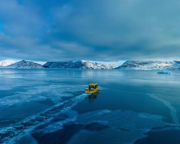 Un barco navega por una bahía con agua congelada a las afueras de Nuuk, Groenlandia.