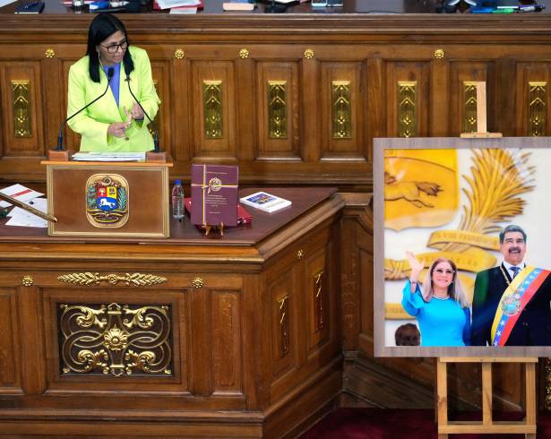 La presidenta encargada de Venezuela, Delcy Rodríguez, habla ante los legisladores junto a una foto del expresidente Nicolás Maduro y su esposa Cilia Flores, en la Asamblea Nacional en Caracas, Venezuela.
