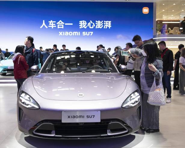 Un visitante toma una fotografía de un Xiaomi SU7 en la exposición Internacional de Automoción de Beijing 2024 en Beijing, China.