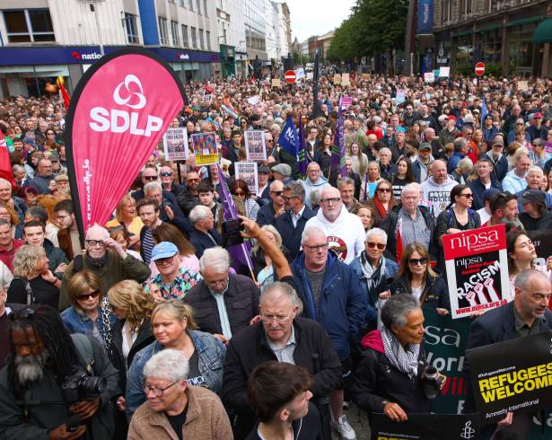 Personas se congregan durante una protesta contra el racismo frente al Ayuntamiento de Belfast, Irlanda del Norte, motivada por los disturbios registrados tras el ataque con cuchillo a un hombre, el sábado 13 de junio de 2026.