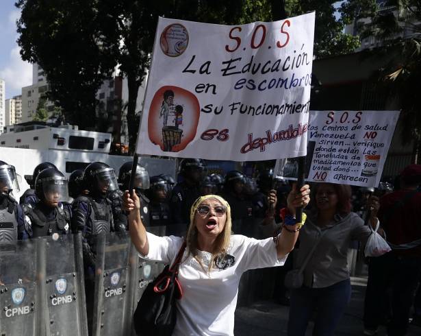 Una persona sostiene un cartel en una manifestación para exigir mejoras salariales en Caracas,Venezuela.