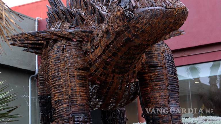 Armas decomisadas se convierten en dinosaurio que da bienvenida en el