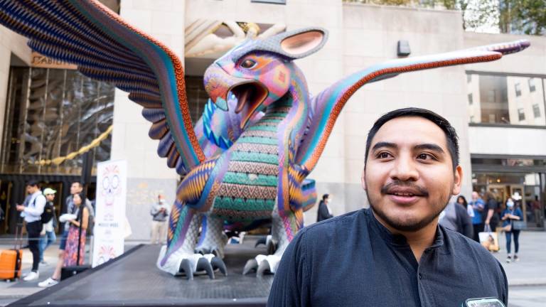$!El artista Ricardo Ángeles de Oaxaca, México se encuentra frente a uno de los dos alebrijes, esculturas de arte folclórico tradicional mexicano, en la plaza del Rockefeller Center como parte de la ‘Semana de México: Dia de Muertos en el Rockefeller Center’ en Nueva York, Nueva York. EFE/EPA/Justin Lane