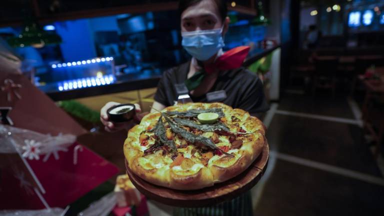 $!Un miembro del personal muestra una pizza cubierta con una hoja de cannabis en un restaurante de Bangkok, Tailandia. AP/Sakchai Lalit