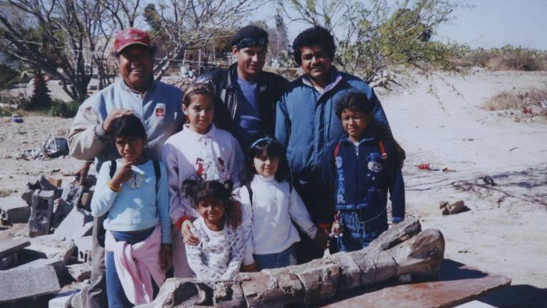 $!﻿La familia de Carmino posa frente al fémur de dinosaurio que encontró hace más de 20 años en Cerro de Tigre.