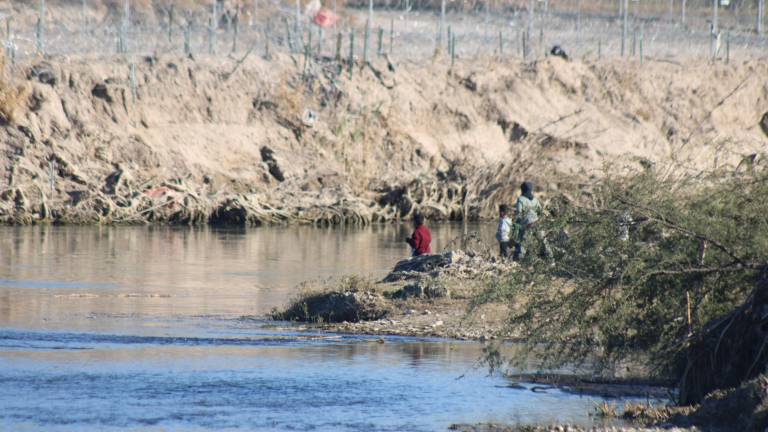 $!﻿Un grupo de niños juegan en una isla sobre el río Bravo. Al fondo, la alambrada que ha colocado el gobierno de Texas.