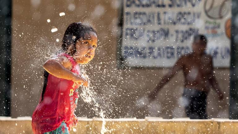 $!Una niña juega con una fuente de agua en un parque para refrescarse durante la ola de calor en Los Angeles, California. EFE/ Etienne Laurent