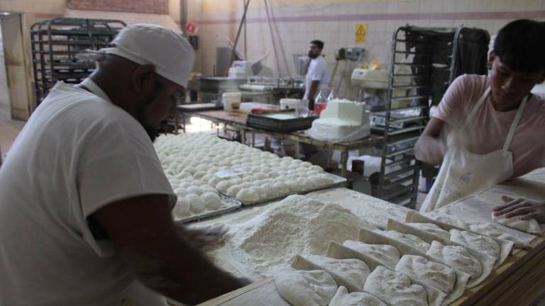 $!Un panadero da forma de pan francés a la masa, un pan que se asemeja a un caracol.