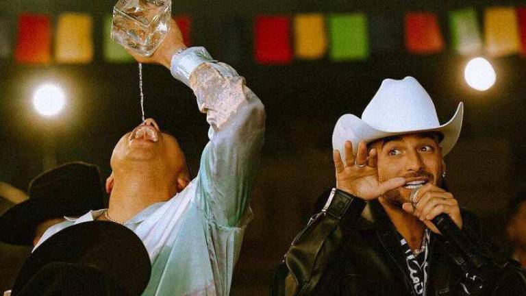 $!Durante todo el video tanto Eduin Caz como Maluma beben y beben algo que parece ser aguardiente y le dan a los integrantes de la banda.
