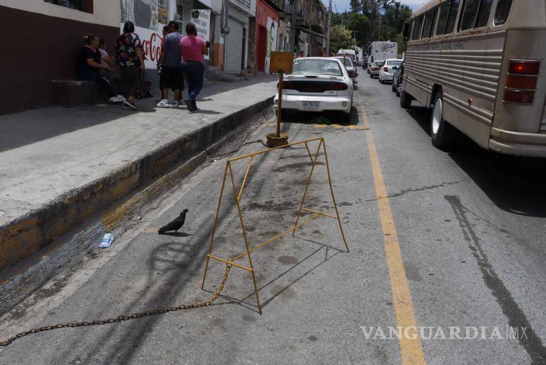 $!A pesar de la prohibición, la práctica de apartar lugares de estacionamiento persiste en Saltillo, incluso sin el pago correspondiente por el derecho de hacerlo.