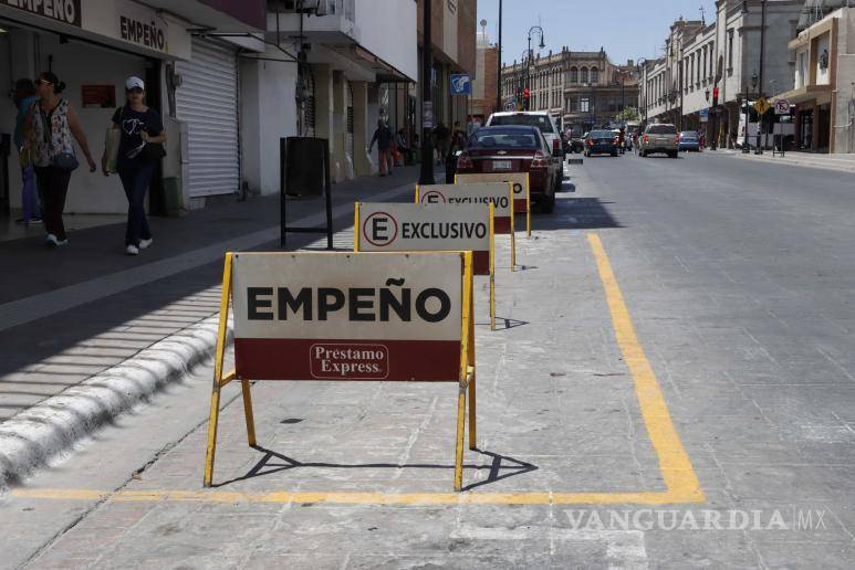 $!Algunos negocios, como Préstamo Express, apartan lugares de estacionamiento con sus propias rejas, a pesar de las regulaciones municipales en Saltillo.