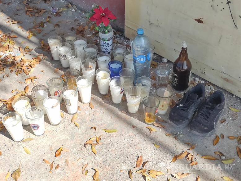 $!En honor a su memoria, familiares y amigos de Donuno colocaron una cruz de veladoras, acompañado de un vaso de agua y sus tenis favoritos.