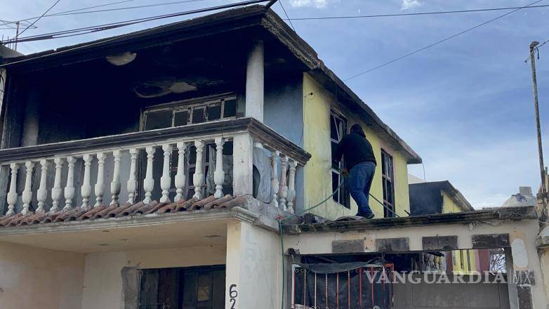 $!Los vecinos de la colonia Nogalera utilizaron una manguera para combatir el incendio en el segundo piso de una casa en la calle Alejandro González.