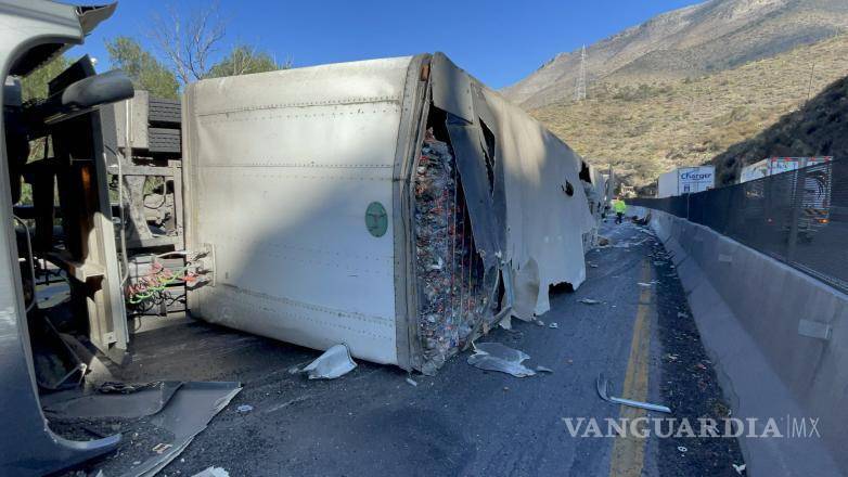 $!El tráiler volcado sobre la carretera Arteaga-Matehuala bloqueó parcialmente la vía, mientras las autoridades trabajaban en su retiro y la limpieza del derrame.