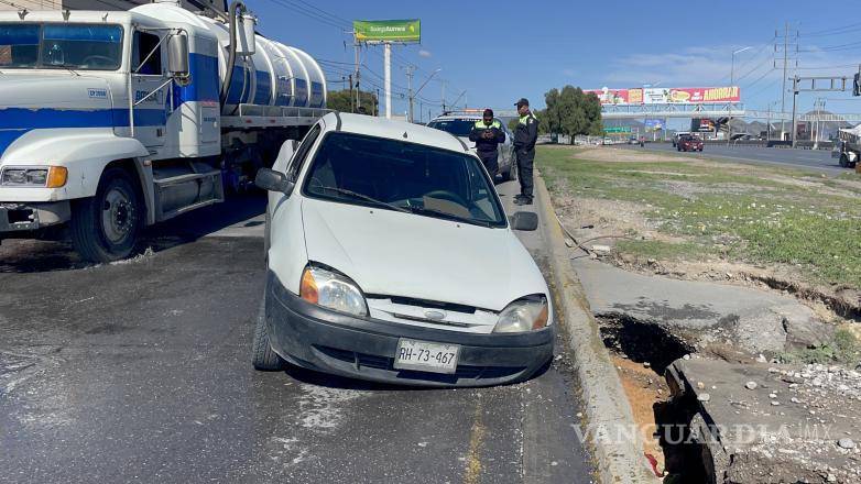 $!El conductor y su acompañante lograron salir antes de que colapsara el asfalto.