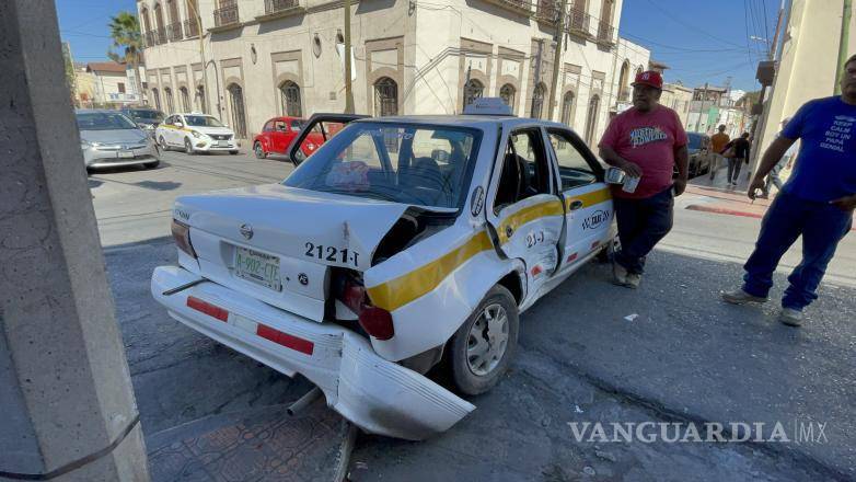 $!El impacto de la camioneta Chevrolet Tracker contra el taxi Nissan Tsuru dejó a la pasajera con lesiones, mientras que el vehículo terminó estrellado contra un poste.