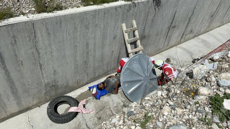 $!Paramédicos de la Cruz Roja descienden al arroyo pluvial para rescatar al obrero lesionado.