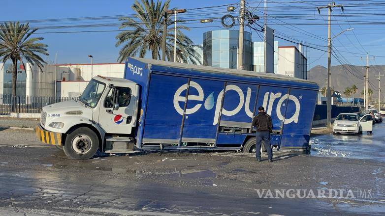 $!El camión de reparto de agua quedó atascado en un bache con agua en la colonia Industrial Valle de Saltillo.