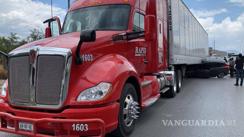 $!La mujer tuvo que ser extraía de su camioneta tras haber quedado atrapada debajo del tráiler.