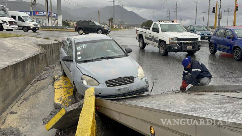 $!Personal de emergencia trabajó para sacar el automóvil del arroyo pluvial tras el accidente vial en Saltillo.