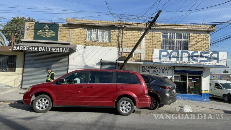 $!La cortina de una barbería resultó dañada tras el impacto del poste derribado.