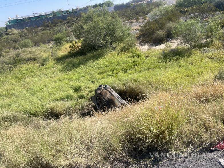 $!El automóvil Chevrolet Versa terminó completamente calcinado tras salir del camino y volcar en un barranco.